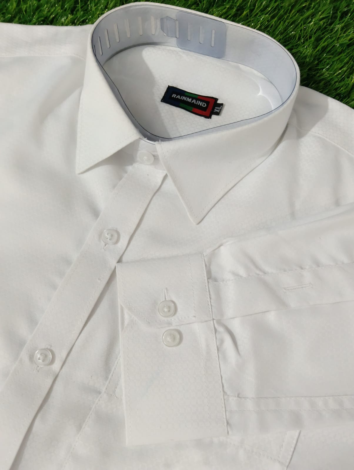 White shirt with a collar tag on grass