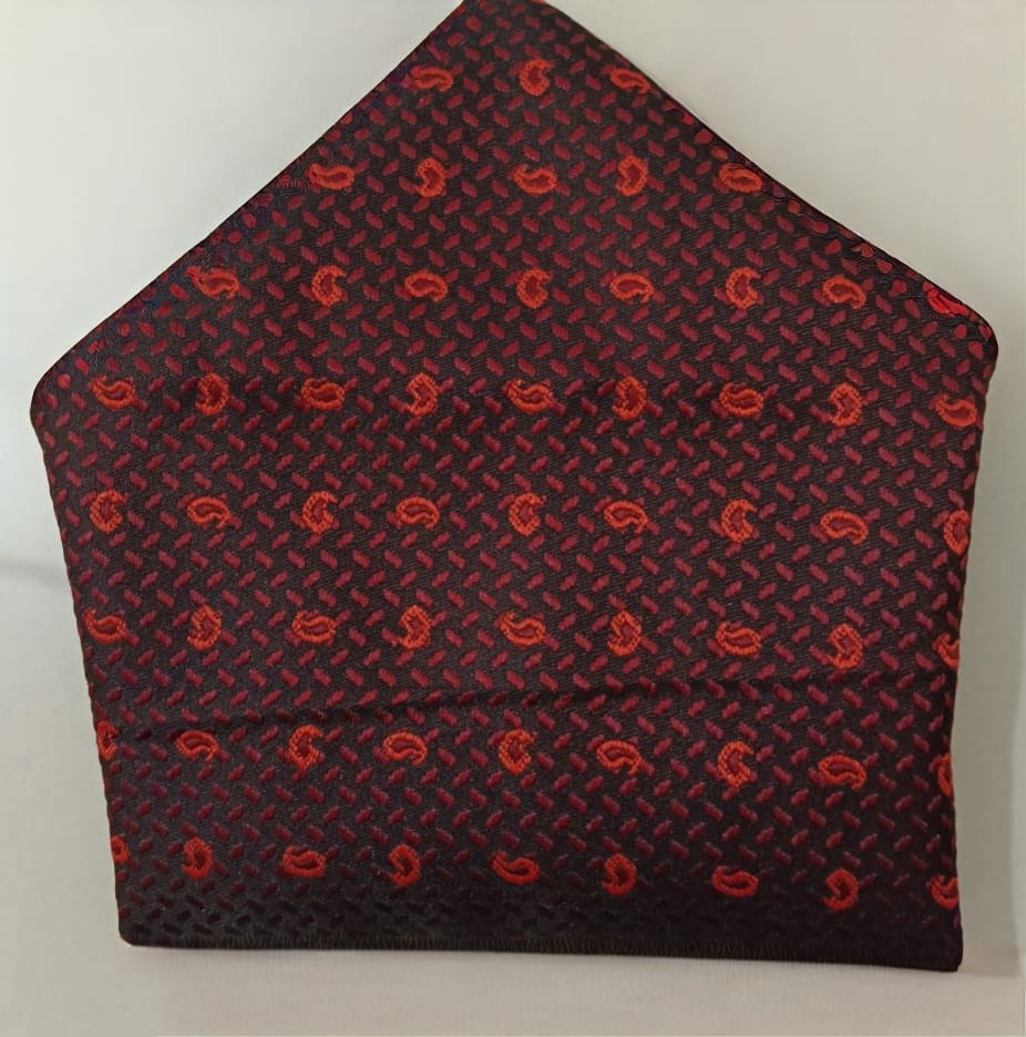 Red paisley patterned pocket square on a gray background