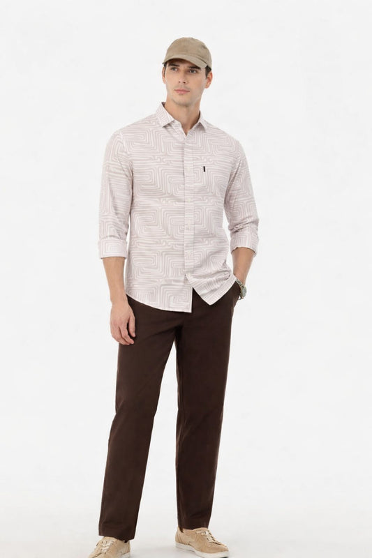 Man wearing a light patterned shirt and brown pants on a white background