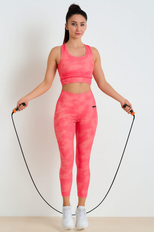 Woman in pink athletic wear holding a jump rope on a plain background