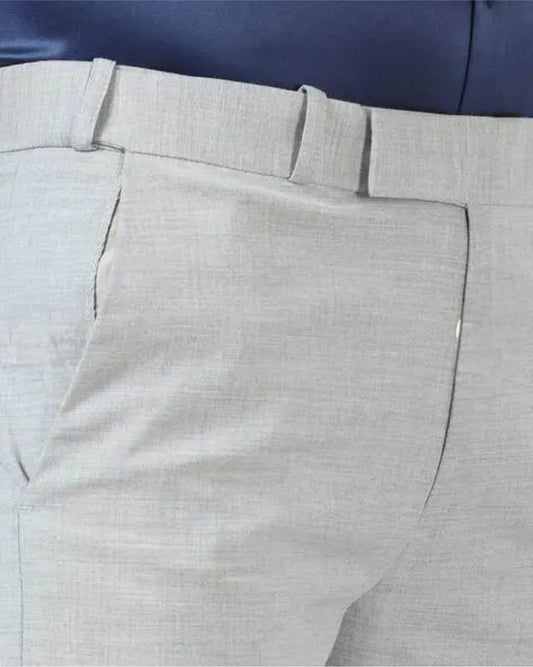 Close-up of light gray pants with a blue background