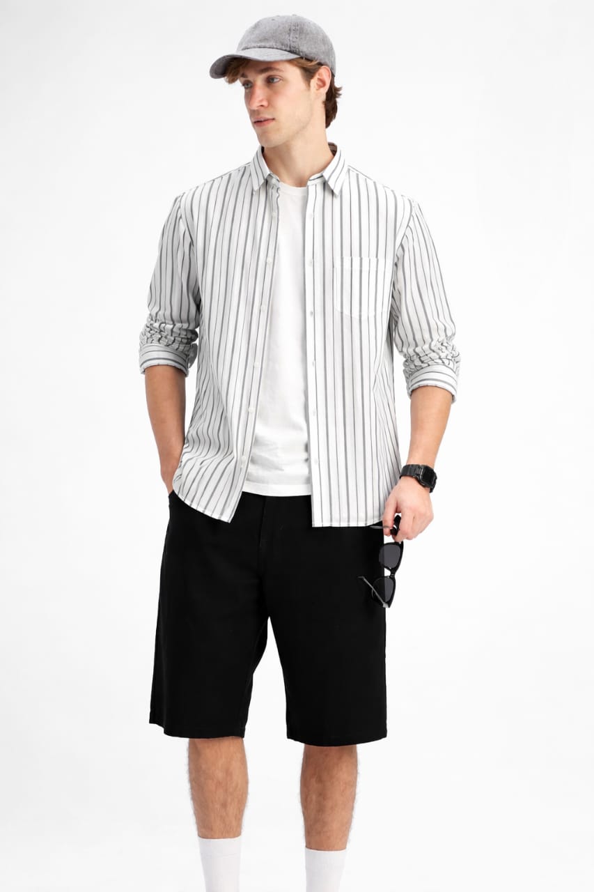 Man wearing a striped shirt, white undershirt, black shorts, and a cap on a white background