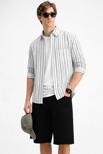 Man wearing a striped shirt, sunglasses, and black shorts on a white background