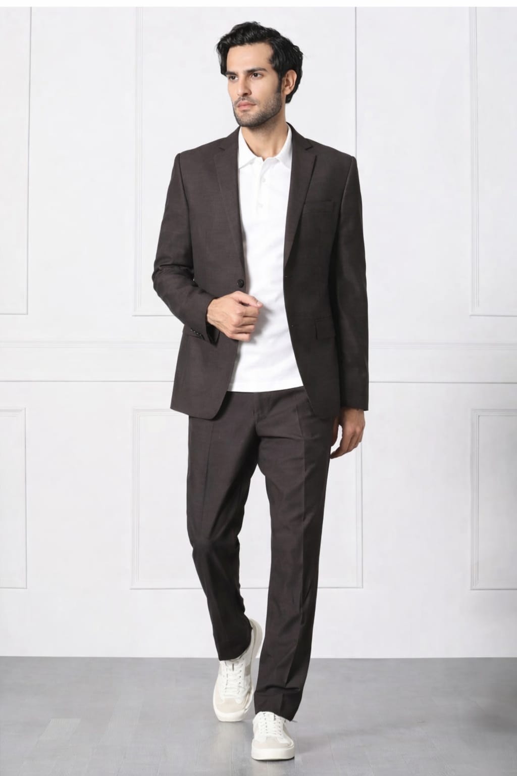 Man wearing a brown suit with a white shirt and white sneakers on a white background