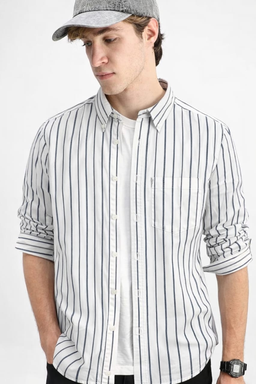 Man wearing a striped shirt and cap on a white background