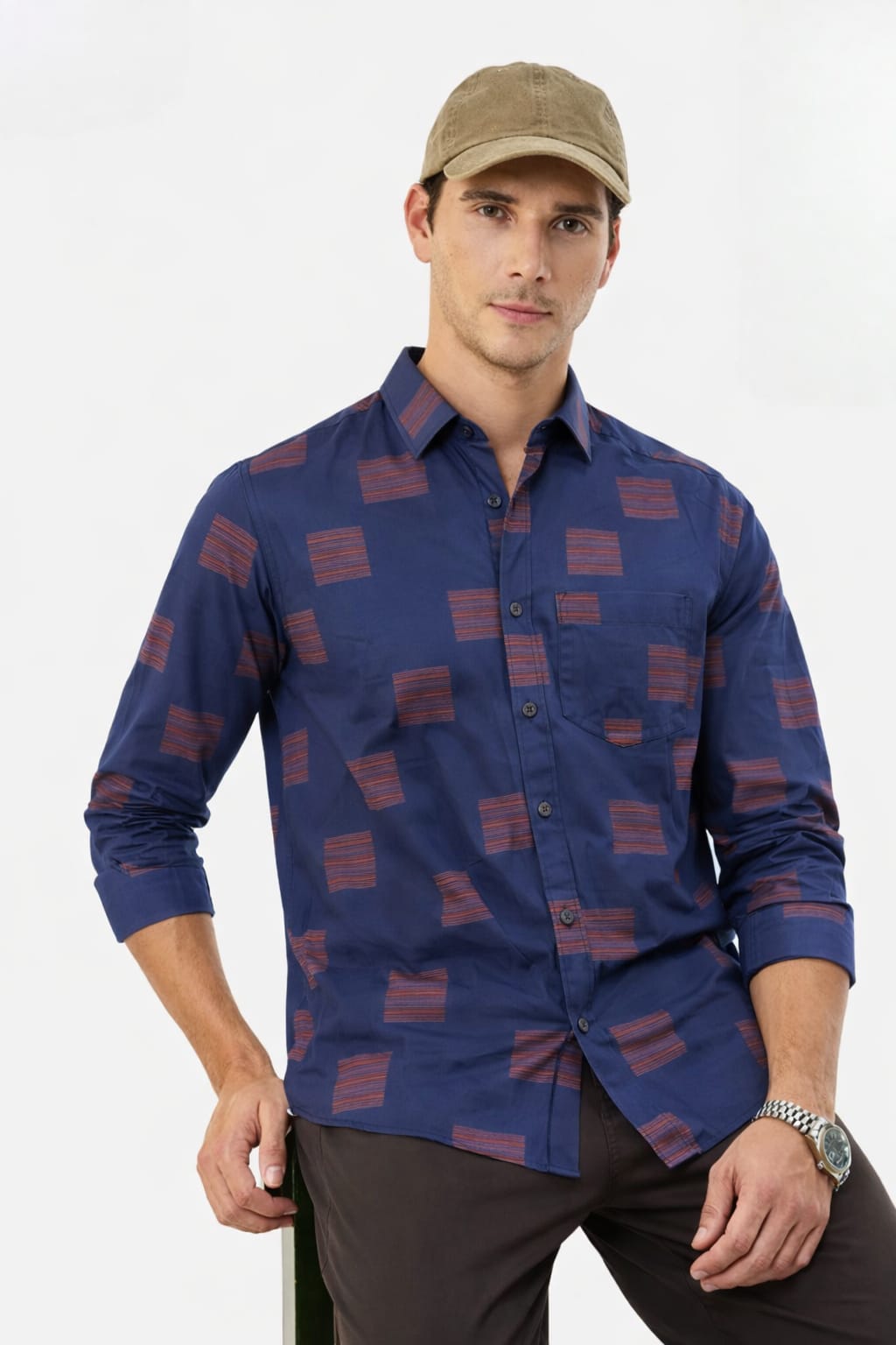 Man wearing a blue patterned shirt and cap on a white background