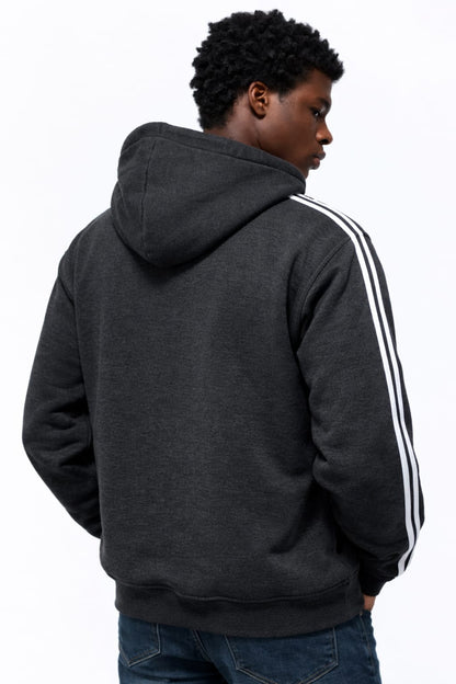 Person wearing a dark gray hoodie with white stripes on the sleeve, facing away from the camera.