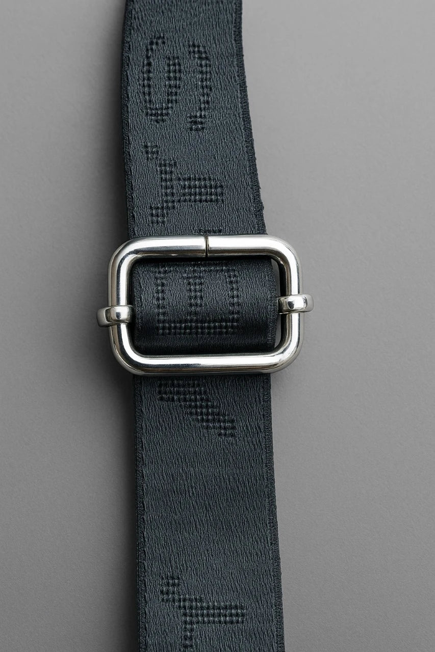 Black belt with silver buckle on a gray background