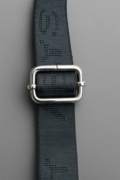 Black belt with silver buckle on a gray background