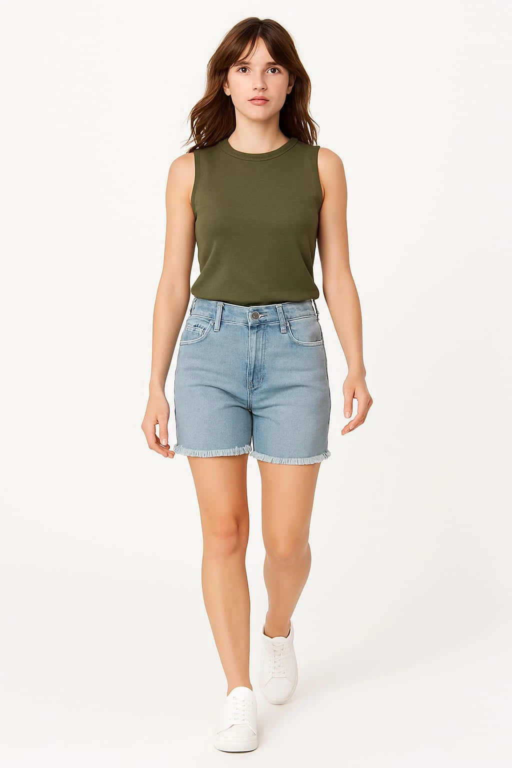 Woman wearing an olive green sleeveless top and light blue denim shorts on a white background