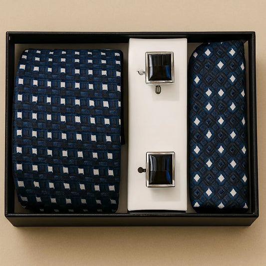 Set of two patterned ties and two tie clips in a black box on a beige background