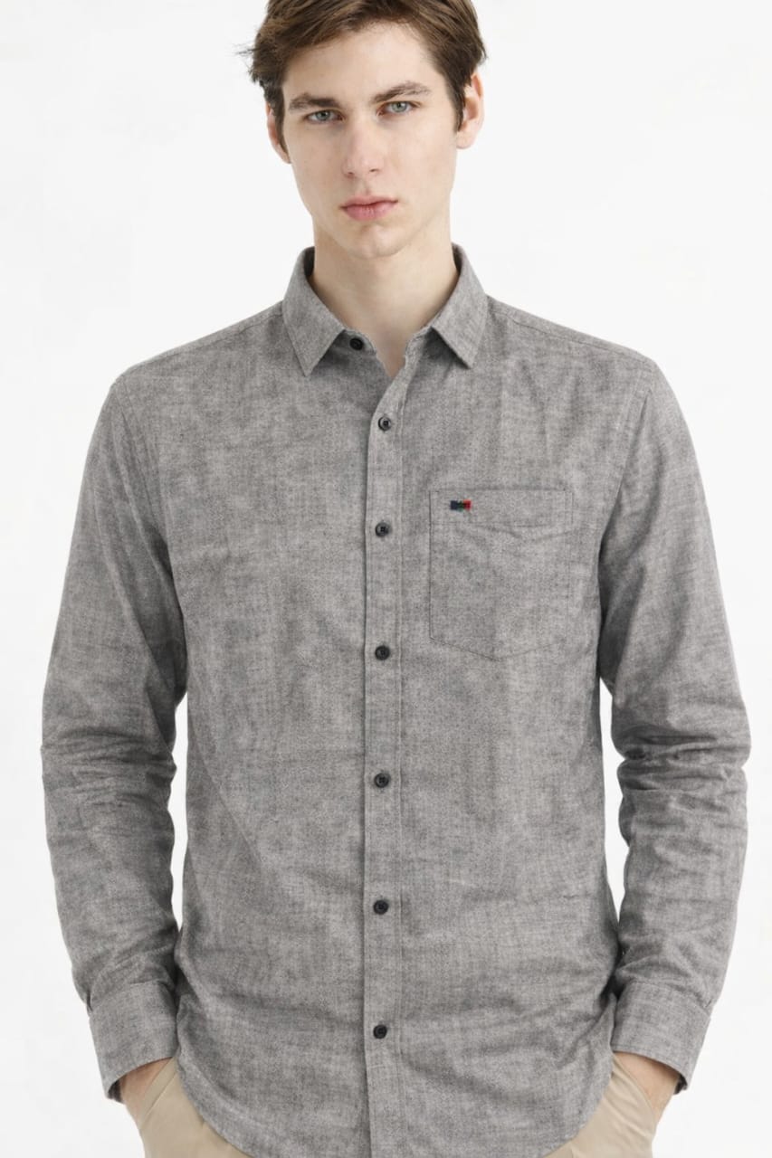 Man wearing a gray button-up shirt with a brand logo on a white background