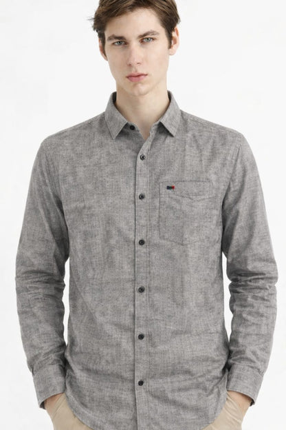 Man wearing a gray button-up shirt with a brand logo on a white background