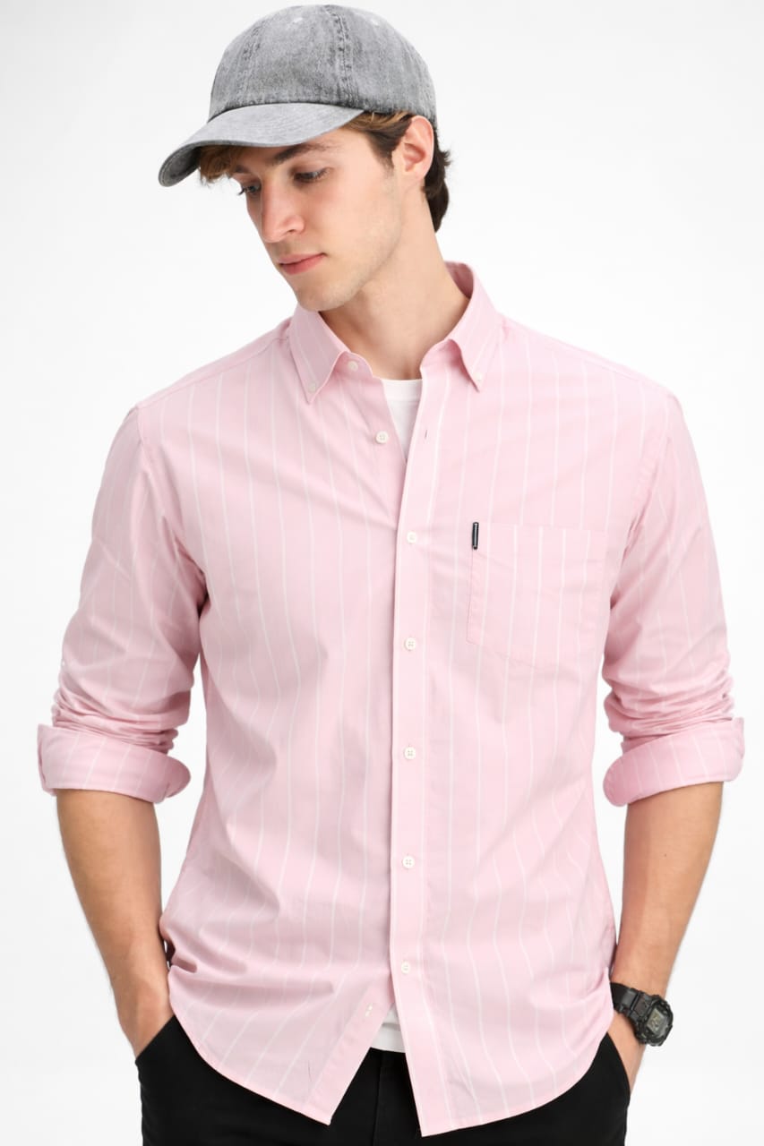 Person wearing a light pink button-up shirt and gray cap on a white background