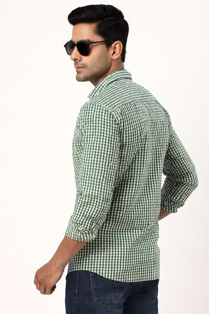 Man wearing a green checkered shirt and sunglasses on a white background