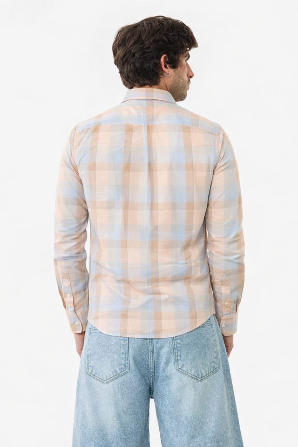 Man wearing a plaid shirt and jeans on a white background