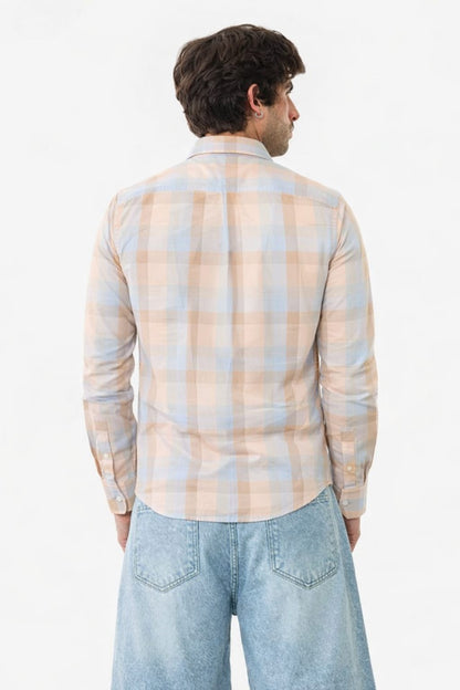 Man wearing a plaid shirt and jeans on a white background