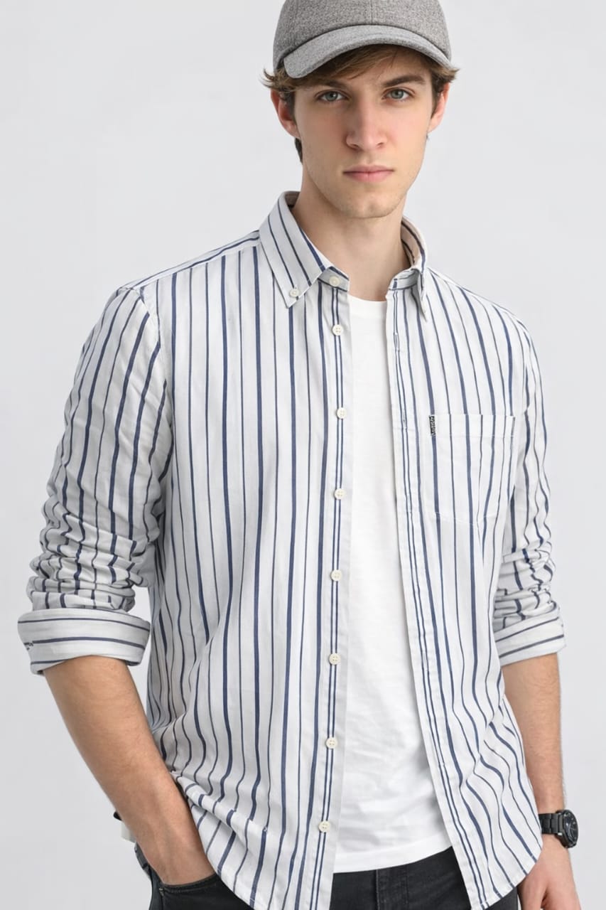 Man wearing a striped shirt and cap on a plain background