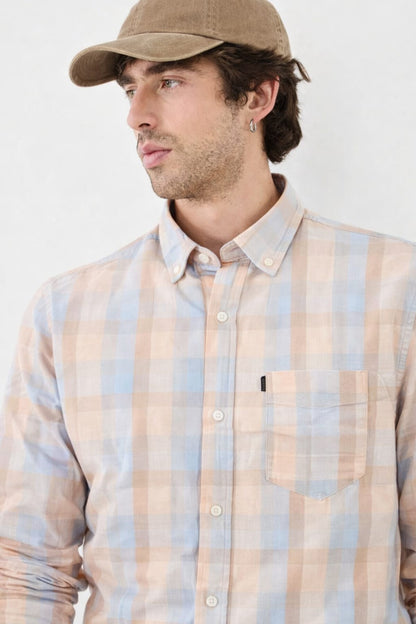 Man wearing a plaid shirt and cap against a white background