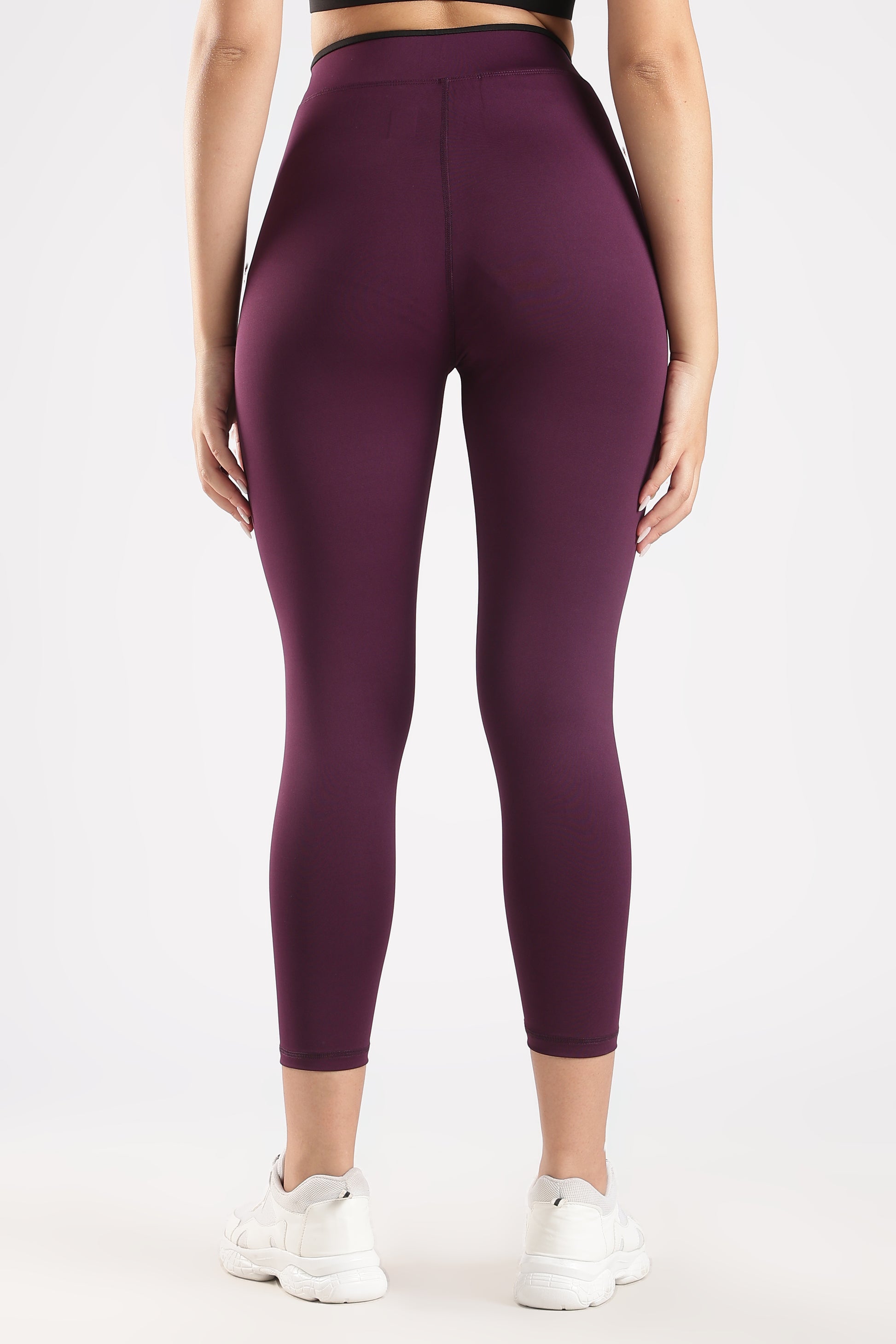 Purple leggings worn by a person on a white background