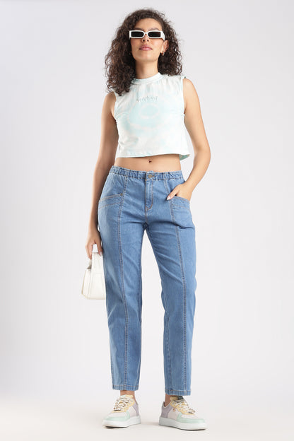 Woman wearing a white sleeveless top and blue jeans on a white background