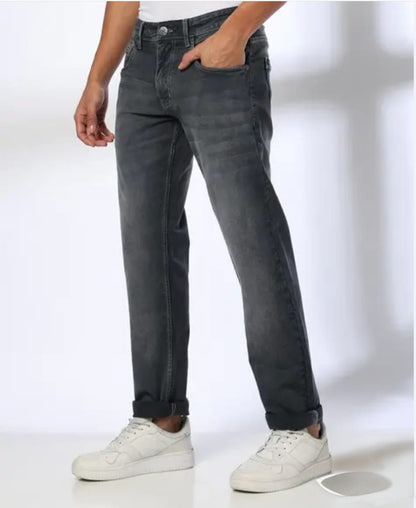 Person wearing dark gray jeans and white sneakers on a white background
