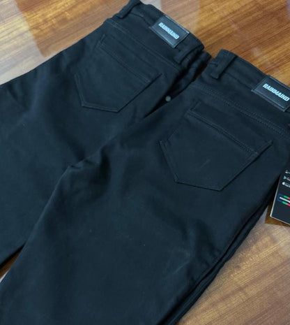 Black pants with brand labels on a wooden surface
