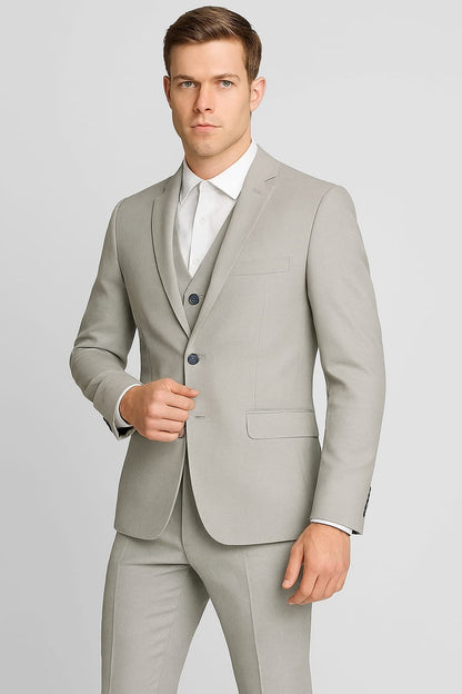 Man wearing a light gray suit with a white shirt on a plain background