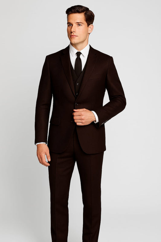 Man wearing a dark brown suit with a white shirt and black tie on a light gray background