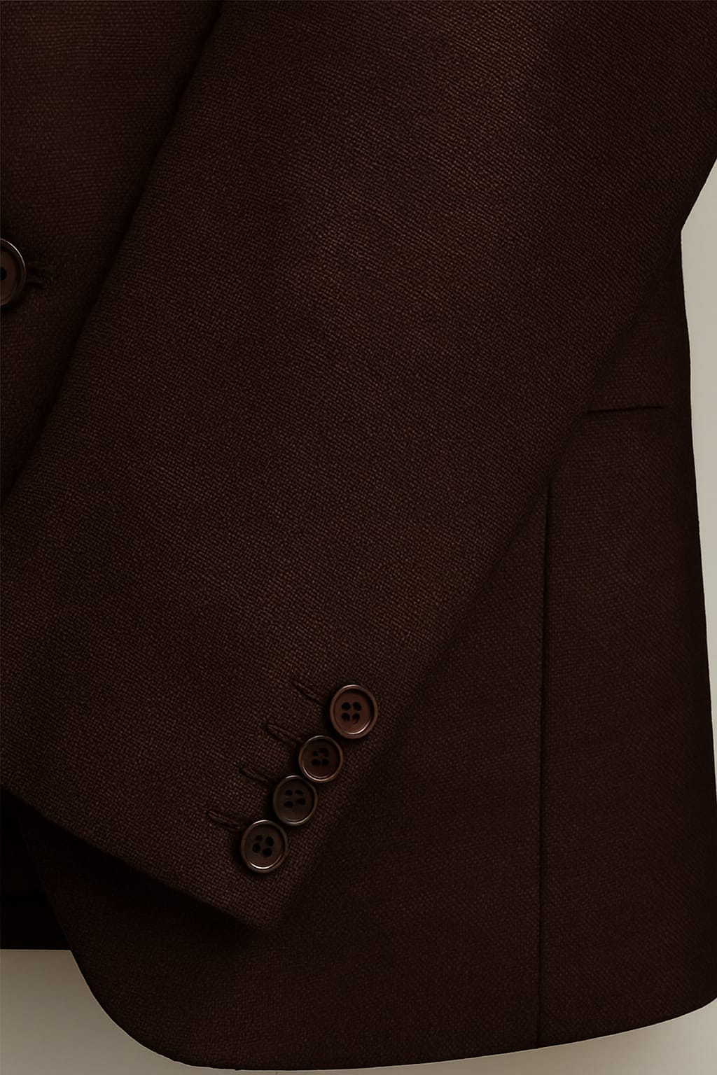 Close-up of a brown suit jacket with buttons on a light background