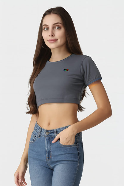 Woman wearing a gray crop top and blue jeans on a white background