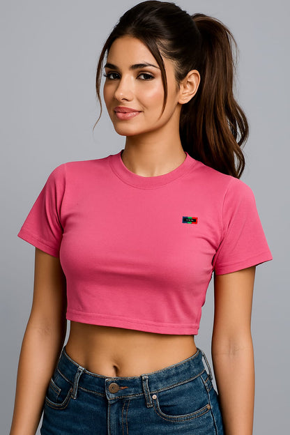 Person wearing a pink crop top and blue jeans on a gray background