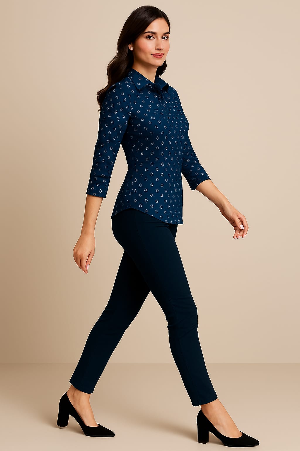 Woman wearing a blue patterned shirt and dark pants on a beige background
