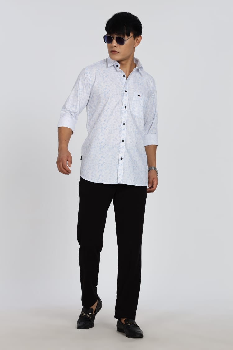 Man wearing a white patterned shirt and black pants on a white background