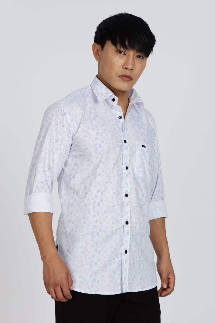 Man wearing a white patterned shirt and black pants on a white background