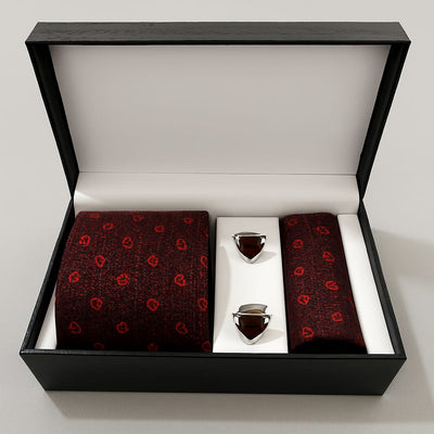 Red patterned tie and pocket square set with silver tie clips in a black box on a white background
