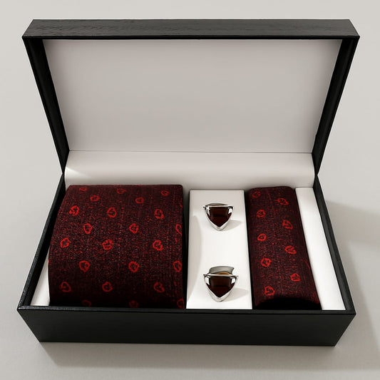 Red patterned tie and pocket square set with silver tie clips in a black box on a white background