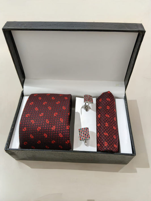 Red patterned tie set with matching pocket square and cufflinks in a black box on a white background