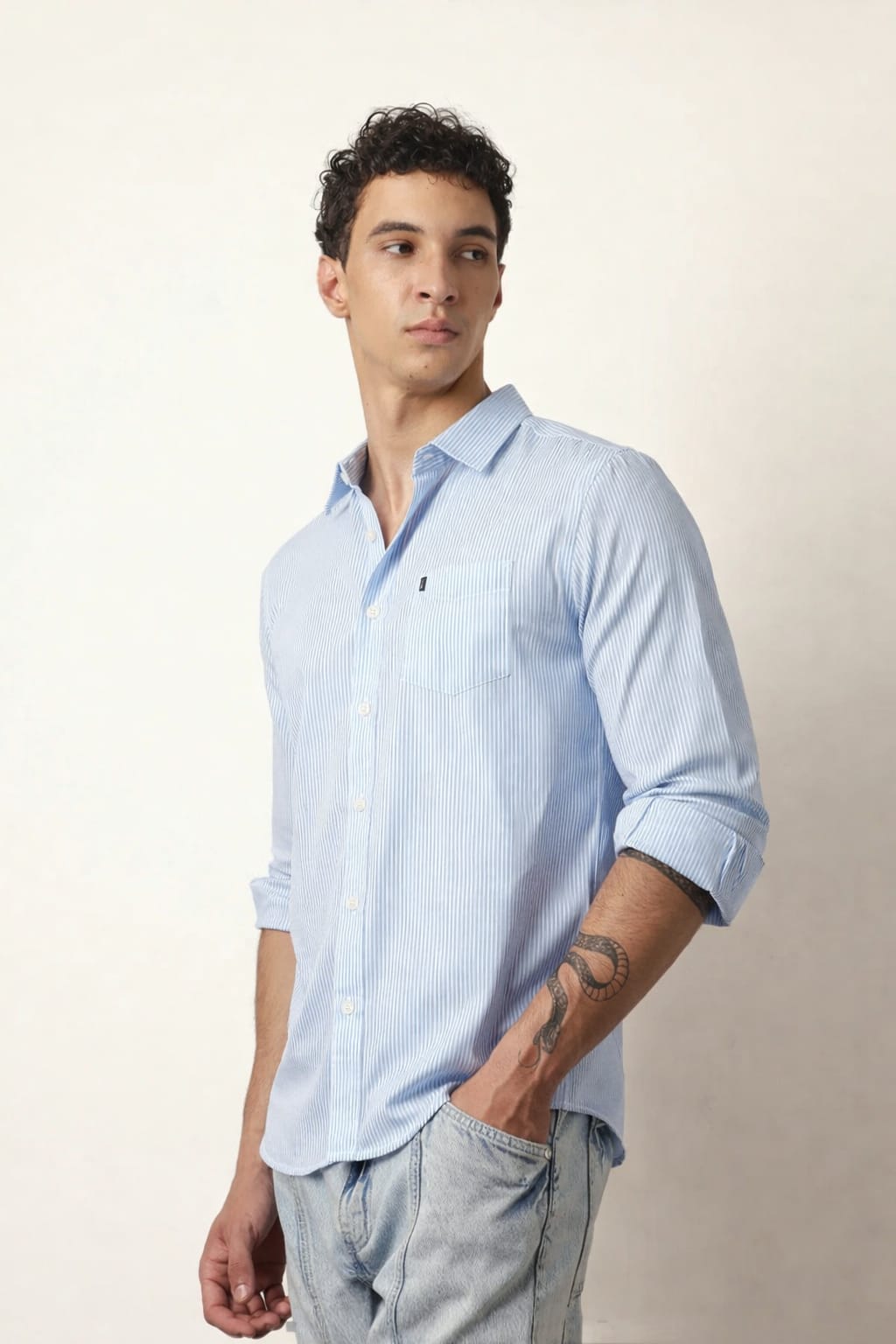 Man wearing a light blue striped shirt against a plain background