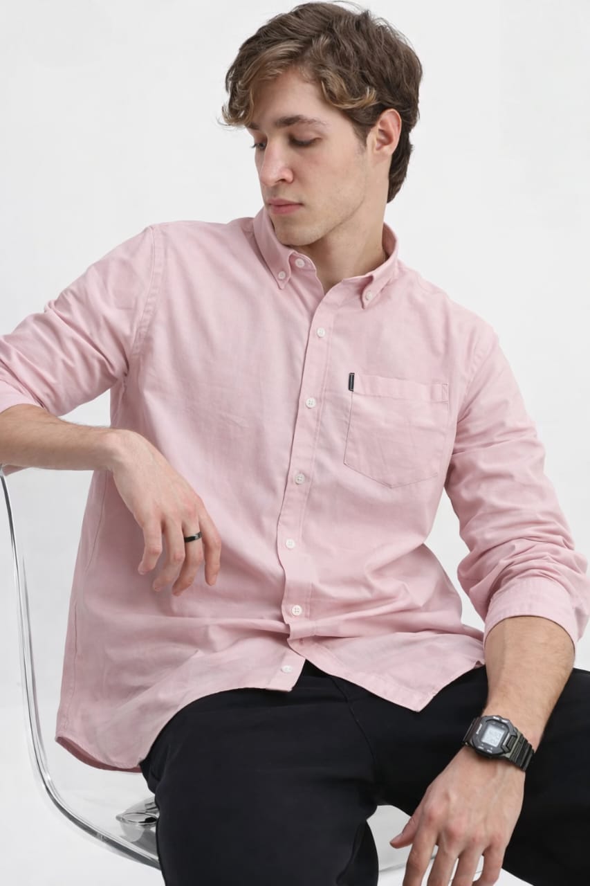 Man wearing a light pink button-up shirt on a white background
