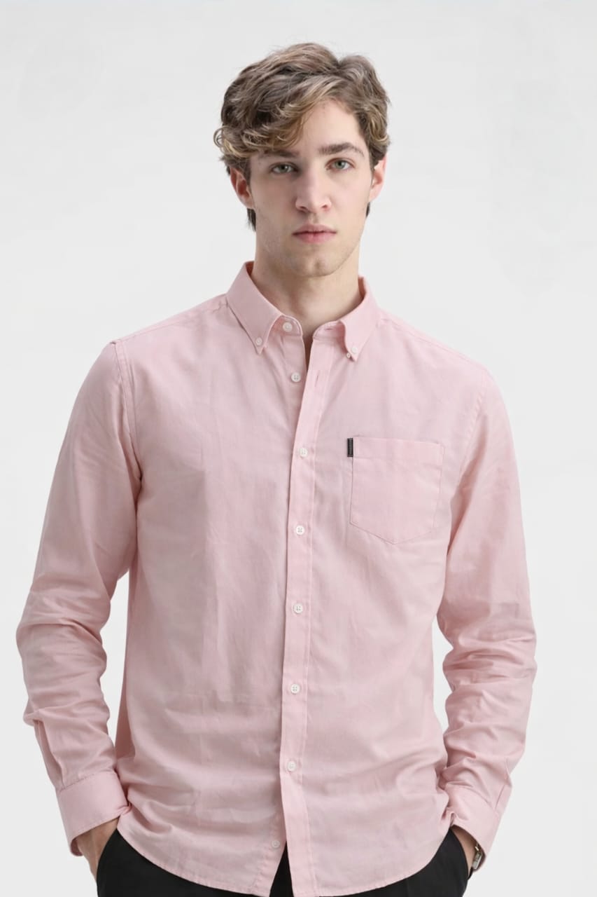 Man wearing a light pink button-up shirt on a white background