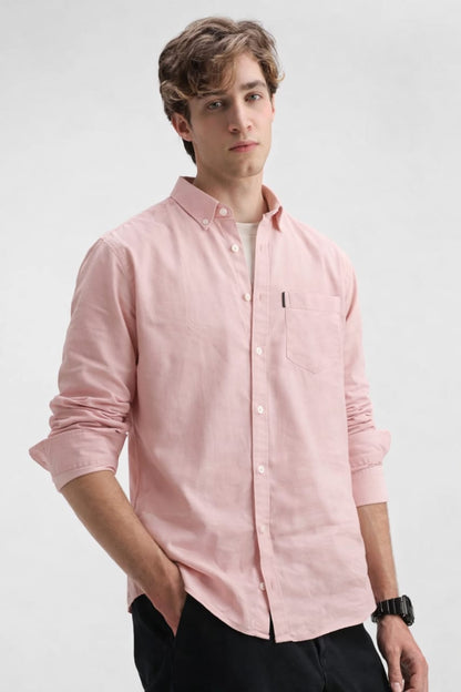 Man wearing a light pink button-up shirt on a white background