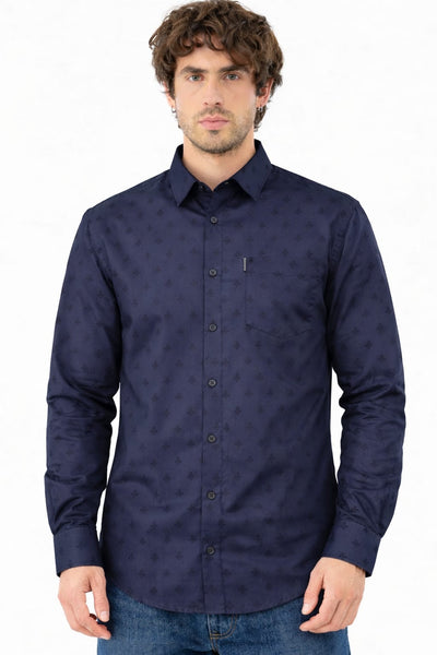 Man wearing a navy blue patterned shirt on a white background