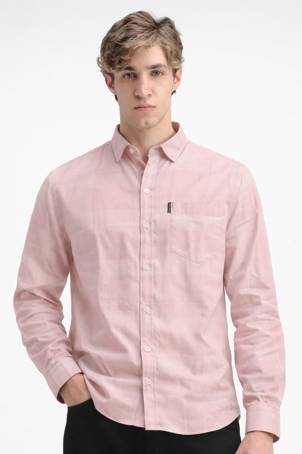 Man wearing a light pink button-up shirt on a white background