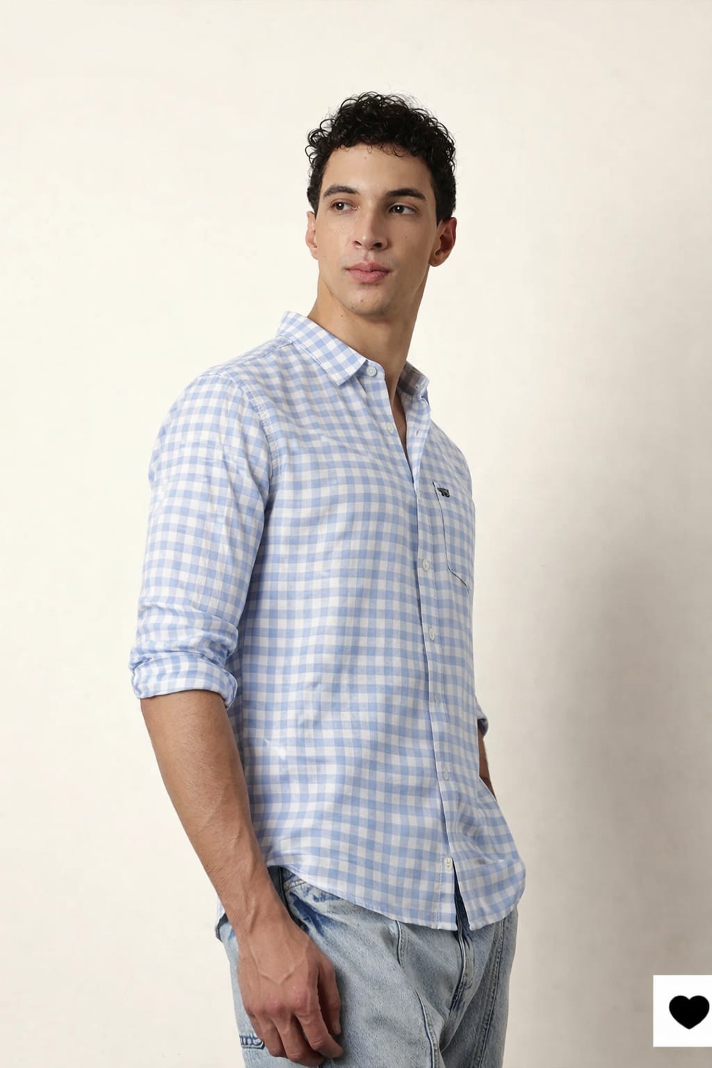 Man wearing a blue checkered shirt against a beige background