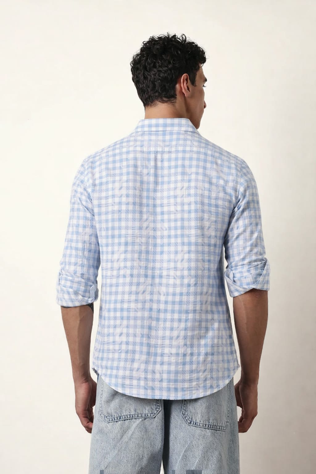 Man wearing a light blue checkered shirt against a white background