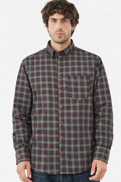 Man wearing a green and red plaid shirt on a white background