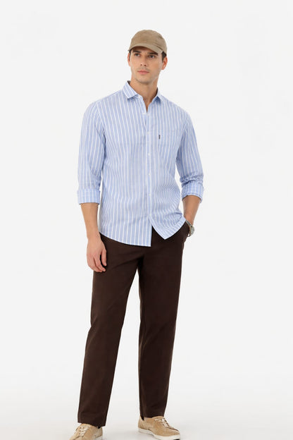 Man wearing a light blue striped shirt and brown pants on a white background