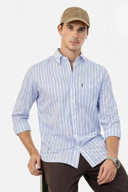 Man wearing a light blue striped shirt and brown cap on a white background