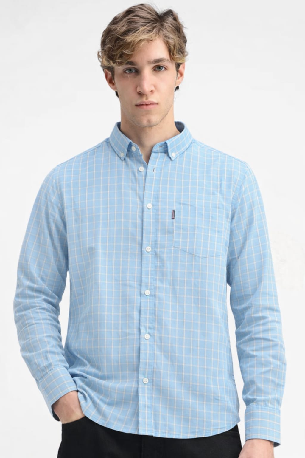 Man wearing a light blue checkered shirt on a white background